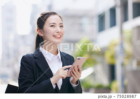 オフィス街でスマホを使用する就活中の大学生 オフィス街でスマホを使用する就活中の大学生 75028987