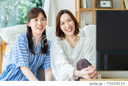 友達とテレビを見る若い女性 75029514