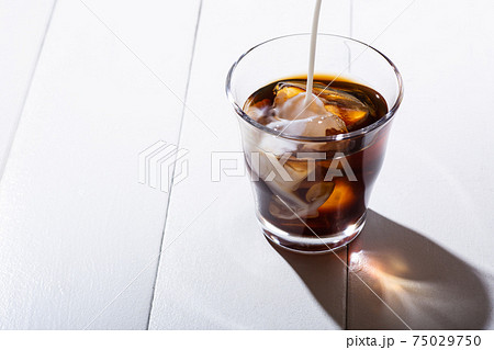 アイスコーヒーにミルクを注ぐ 75029750