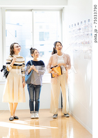 大学のキャンパスで掲示板を見る女子大生　撮影協力：中央工学校附属日本語学校 75033790