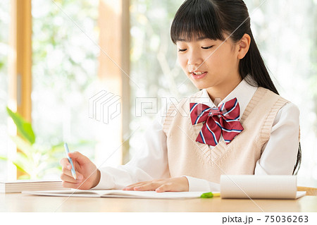 家で勉強する中学生の女の子の写真素材