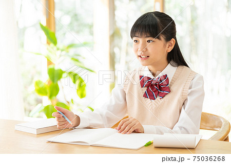 家で勉強する中学生の女の子の写真素材