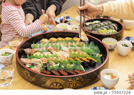 自宅で出前寿司を食べる家族 自宅で出前寿司を食べる家族 75037228