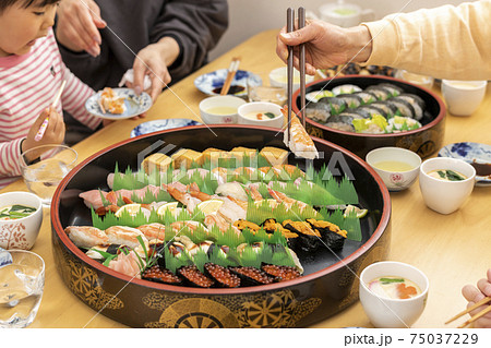 自宅で出前寿司を食べる家族 自宅で出前寿司を食べる家族 75037229