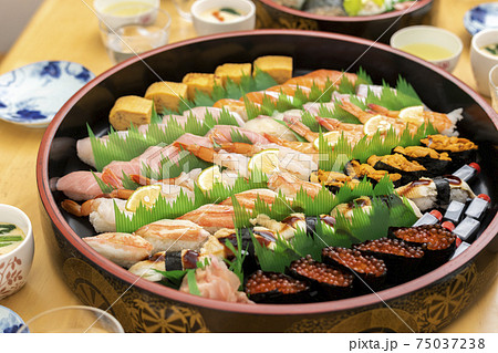 テーブルに並んだ料理と出前寿司 75037238