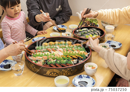 自宅で出前寿司を食べる家族 75037250