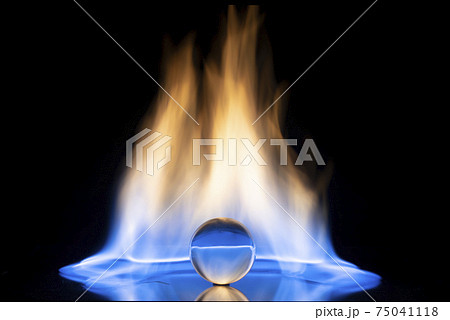 Glass ball with fire flames on black background. 75041118