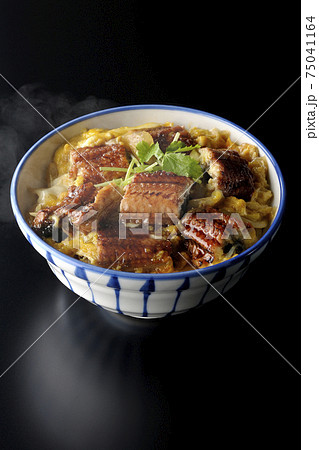 鰻の蒲焼きを卵でとじた熱々うな玉丼を黒背景で撮影 75041164