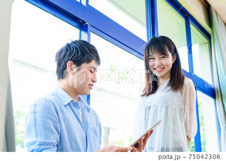 大学の教室、講義室でタブレット端末を見る大学生 75042306