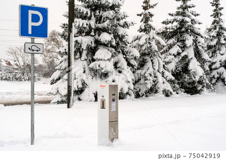 Modern electric car charging station after heavy snowfall 75042919