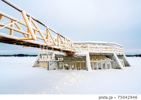 Ice and snow covered metal constructions of floodgate and dam 75042946