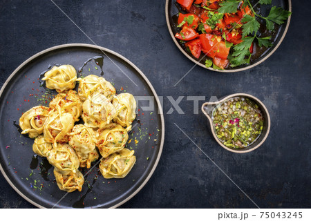 Traditional Kazakh manti steamed with mincemeat and tomato salad  75043245