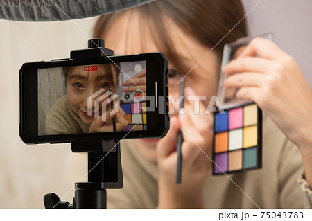 スマートフォンでメイクの動画を撮影する女性 75043783