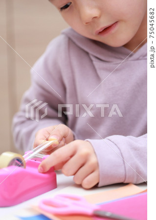 セロハンテープをカットして工作する女の子 75045682