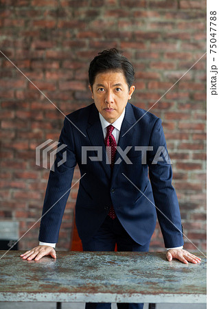 怒った表情のスーツを着た男性 75047788