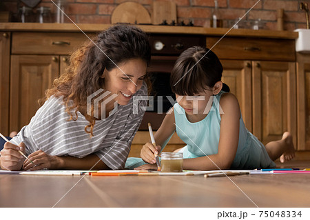 Loving young mom and small daughter drawing together 75048334