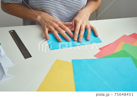 DIY concept. Woman make origami easter rabbit from color paper. Origami lessons DIY concept. Woman make origami easter rabbit from color paper. Origami lessons 75048451