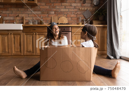 Happy Hispanic mom play at home with daughter Happy Hispanic mom play at home with daughter 75048470