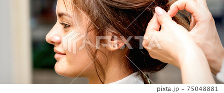 Hairstylist styling hair of woman Hairstylist styling hair of woman 75048881