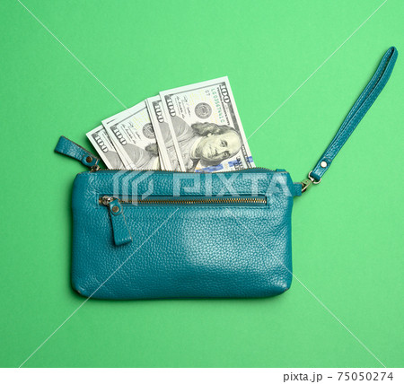 open wallet with paper hundred dollar bills on green background 75050274