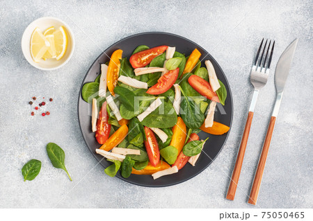 Salad of boiled squid, fresh tomatoes, spinach leaves. Delicious bright diet dish with vegetables and seafood. Salad of boiled squid, fresh tomatoes, spinach leaves. Delicious bright diet dish with vegetables and seafood. 75050465