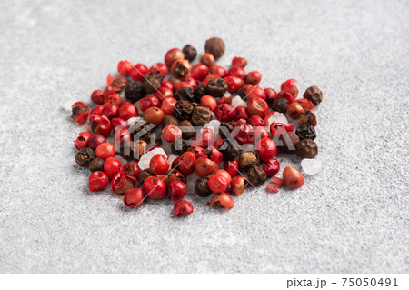 A mixture of black and red pepper peas on a concrete background. A mixture of black and red pepper peas on a concrete background. 75050491