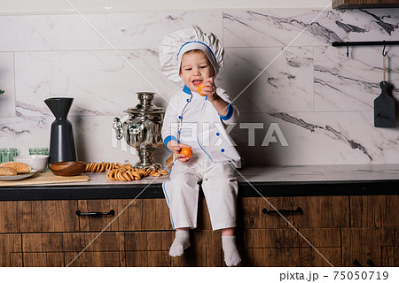 Portrait of a little boy cook at kitchen. Different occupations. Isolated over white background. Portrait of a little boy cook at kitchen. Different occupations. Isolated over white background. 75050719