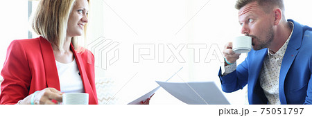 Man and woman are drinking coffee and studying documents 75051797