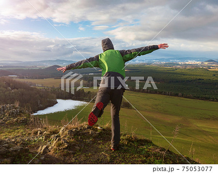 Man show airplane fly used arms as wings on rocky peak. Man show airplane fly used arms as wings on rocky peak. 75053077