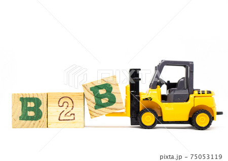 Toy forklift hold letter block b to complete word b2b (abbreviation of business to business) on wood background 75053119