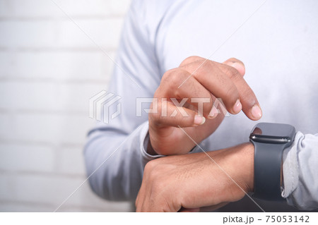 man's hand using smart watch. man's hand using smart watch. 75053142