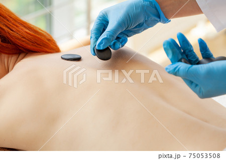 Beautiful woman spa hot stone massage beauty Treatments 75053508