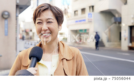街頭インタビューを受ける女性の写真素材