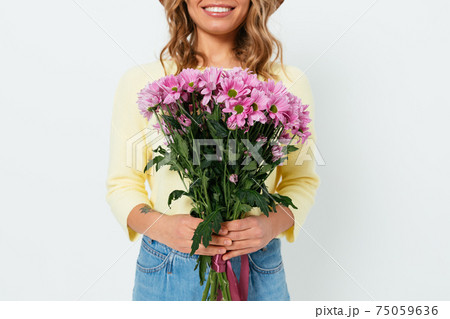 Close-up happy smiling young woman holding bouquet of fresh pink flowers Close-up happy smiling young woman holding bouquet of fresh pink flowers 75059636