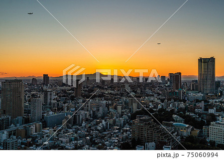 日本の東京都市景観 都心上空を飛ぶ2機の航空機。（渋谷ストリームや六本木ヒルズ、富士山…） 75060994