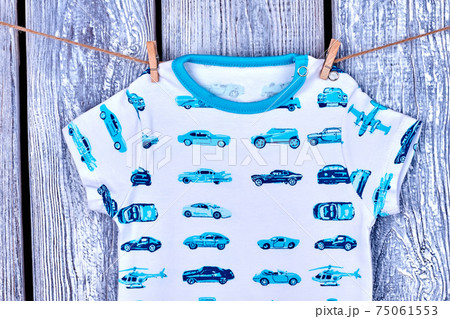Baby boy t-shirt hanging on rope. 75061553