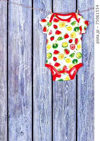 Baby soft bodysuit hanging on clothesline. 75061554