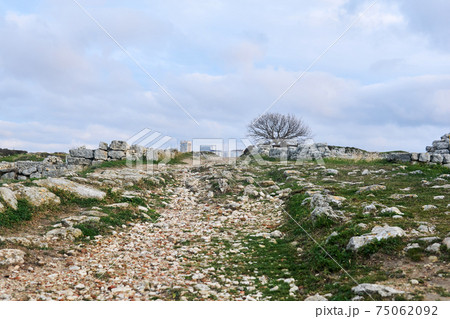 antique road among ancient ruins leads to a modern city on the horizon antique road among ancient ruins leads to a modern city on the horizon 75062092