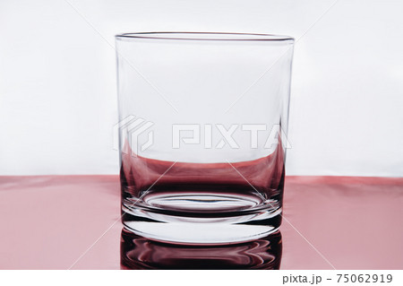 Empty small shot glass on white background. Empty small shot glass on white background. 75062919