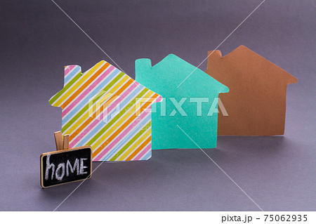 Miniature cardboard houses on grey background. Miniature cardboard houses on grey background. 75062935