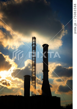 High exhaust chimney against blue sky 75063588