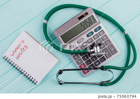 Flat lay medical composition include calculator notepad stethoscope on a blue pastel background. 75063794