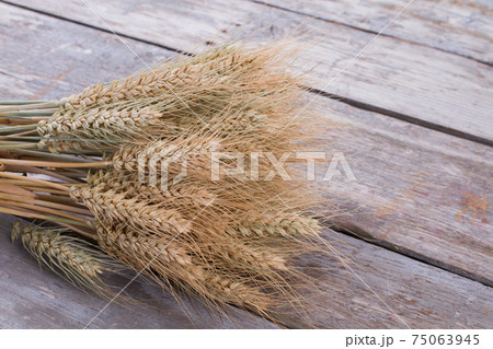 Cereal ears on wooden background. 75063945