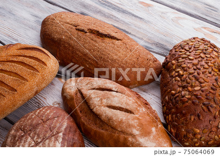 Delicious bread loaves on wooden background. Delicious bread loaves on wooden background. 75064069
