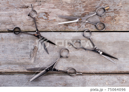 Hairdressing scissors on rustic wooden background. Hairdressing scissors on rustic wooden background. 75064096