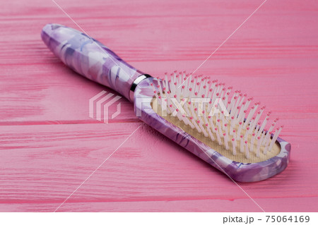 Female hair brush on pink background. 75064169