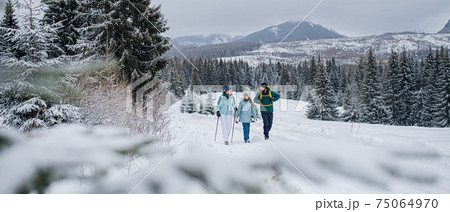 Family with small daughter on a walk outdoors in winter nature, Tatra mountains Slovakia. Family with small daughter on a walk outdoors in winter nature, Tatra mountains Slovakia. 75064970