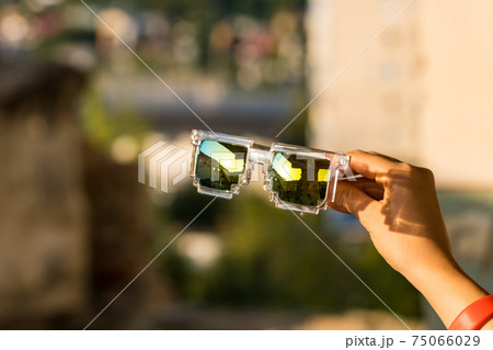 Pixel Model sunglasses hold in hand closeup in a sunny day. Selective focus Pixel Model sunglasses hold in hand closeup in a sunny day. Selective focus 75066029