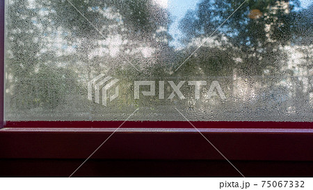結露した冬の窓から見た風景 結露した冬の窓から見た風景 75067332