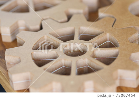 Large wooden gears lie on table closeup Large wooden gears lie on table closeup 75067454